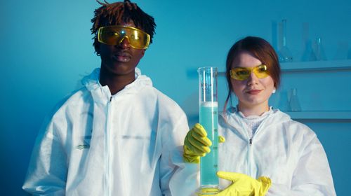 man-woman-looking-camera-while-holding-big-graduated-cylinder-stock-photo