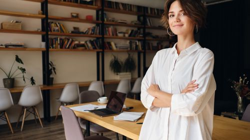 young-attractive-woman-white-shirt-dreamily-looking-camera-with-desk-background-modern-office